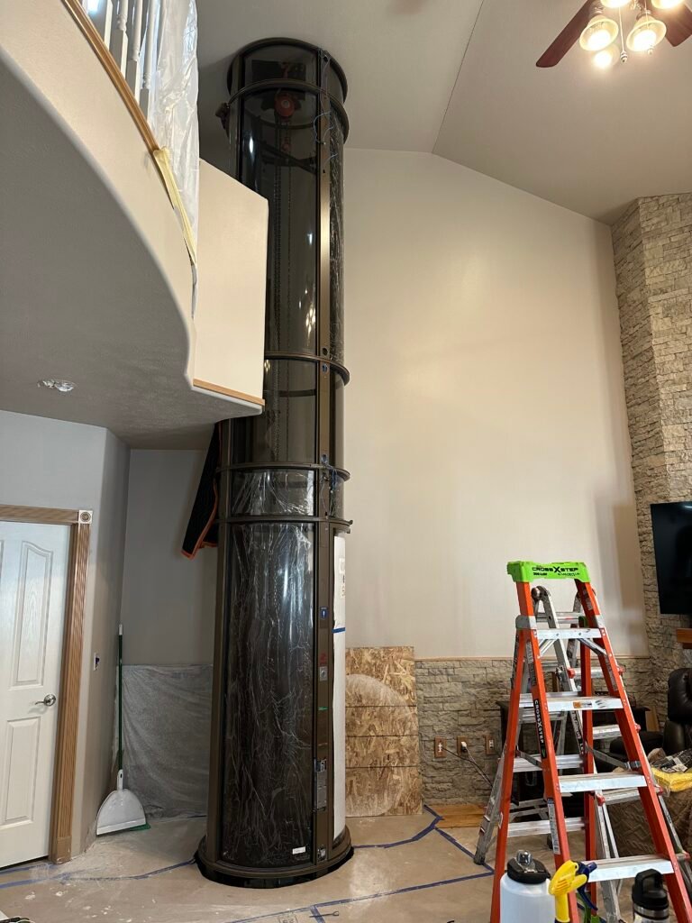 Pneumatic home elevator installation in progress showing control panel and wiring in North Texas home